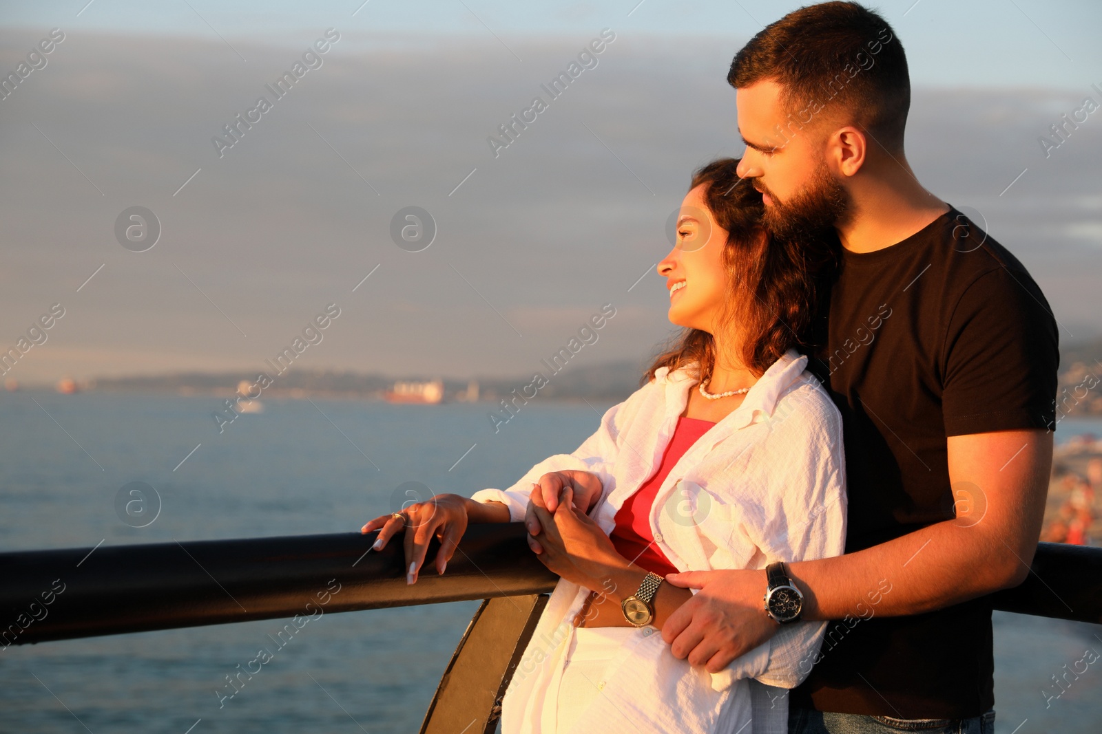 Photo of Happy young couple hugging on sea embankment