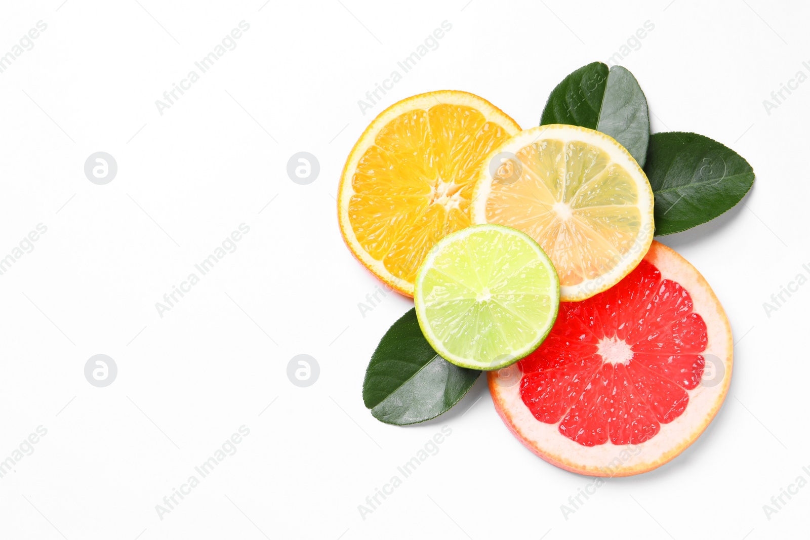 Photo of Slices of fresh ripe citrus fruits and green leaves on white background, flat lay. Space for text