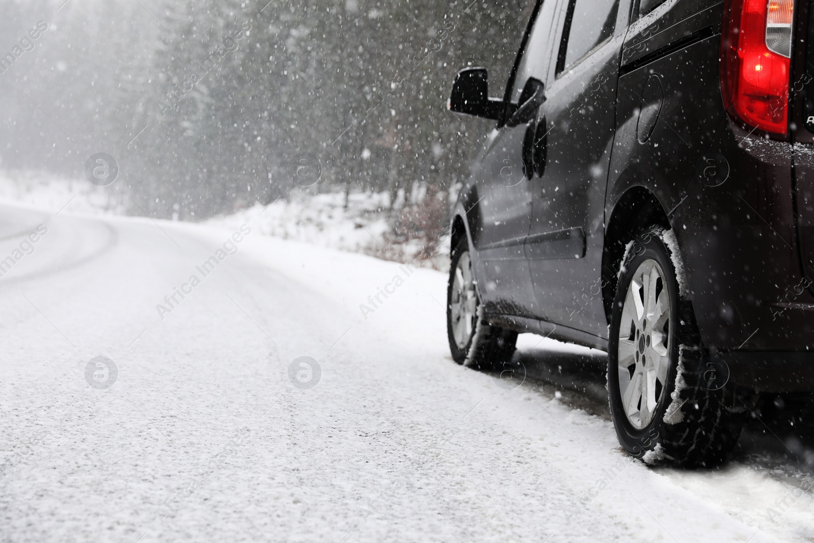 Photo of Country road with car on snowy winter day. Space for text