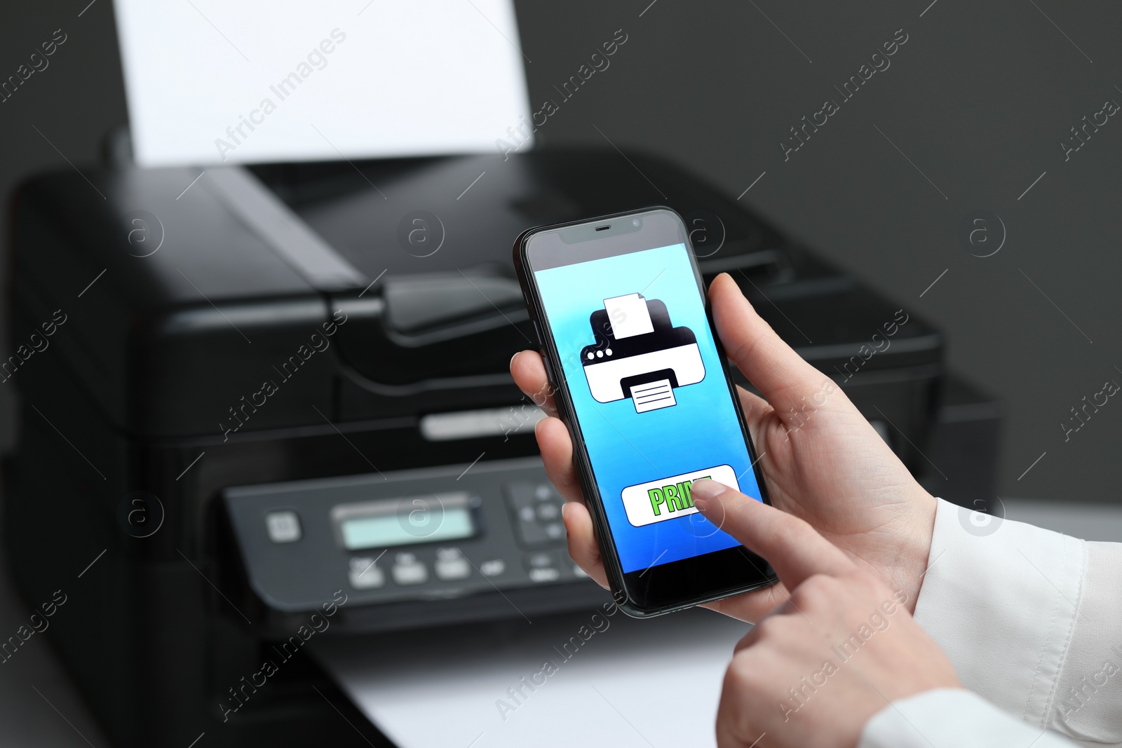 Photo of Man using printer management application on mobile phone indoors, closeup and space for text