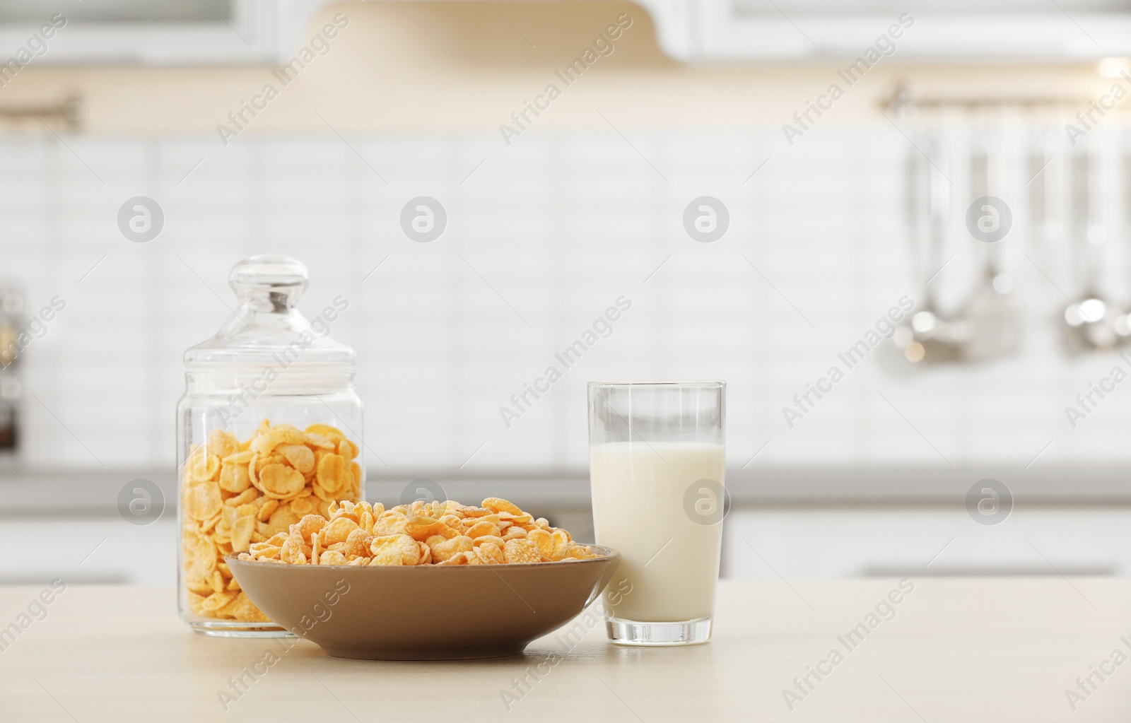 Photo of Cornflakes with glass of milk on kitchen table