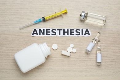 Photo of Flat lay composition with word Anesthesia and drugs on wooden table