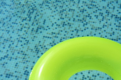 Photo of Light green inflatable ring floating in swimming pool, top view. Space for text