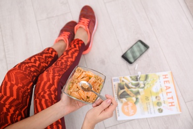 Photo of Young woman in fitness clothes having healthy breakfast at home, closeup