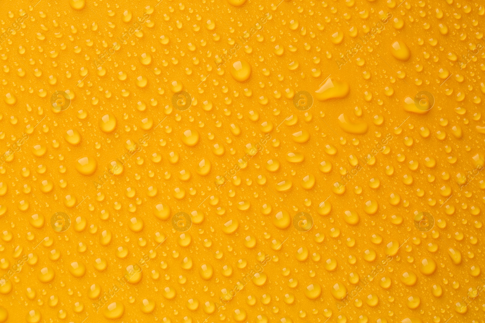 Photo of Water drops on orange background, top view