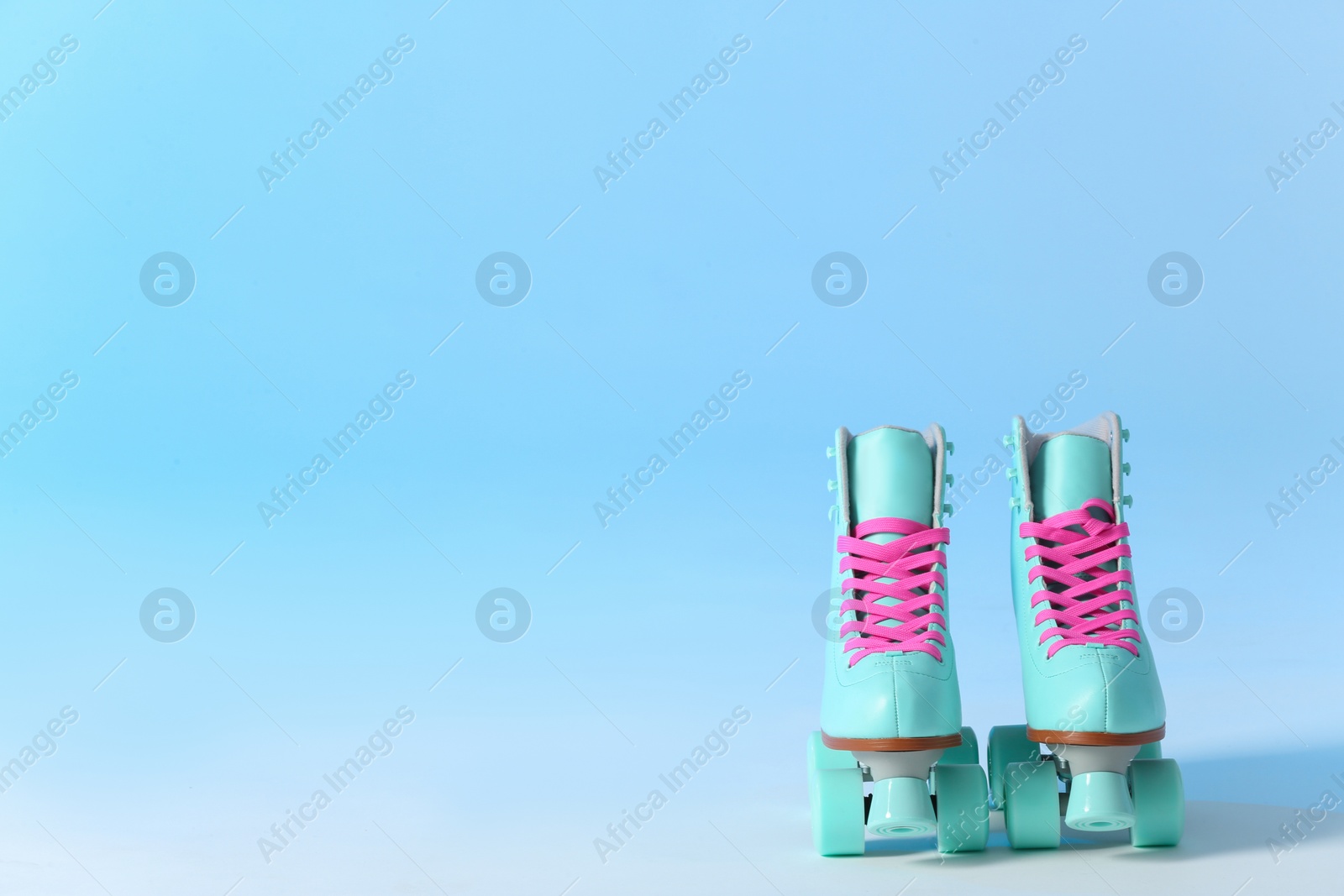 Photo of Pair of vintage roller skates on color background. Space for text