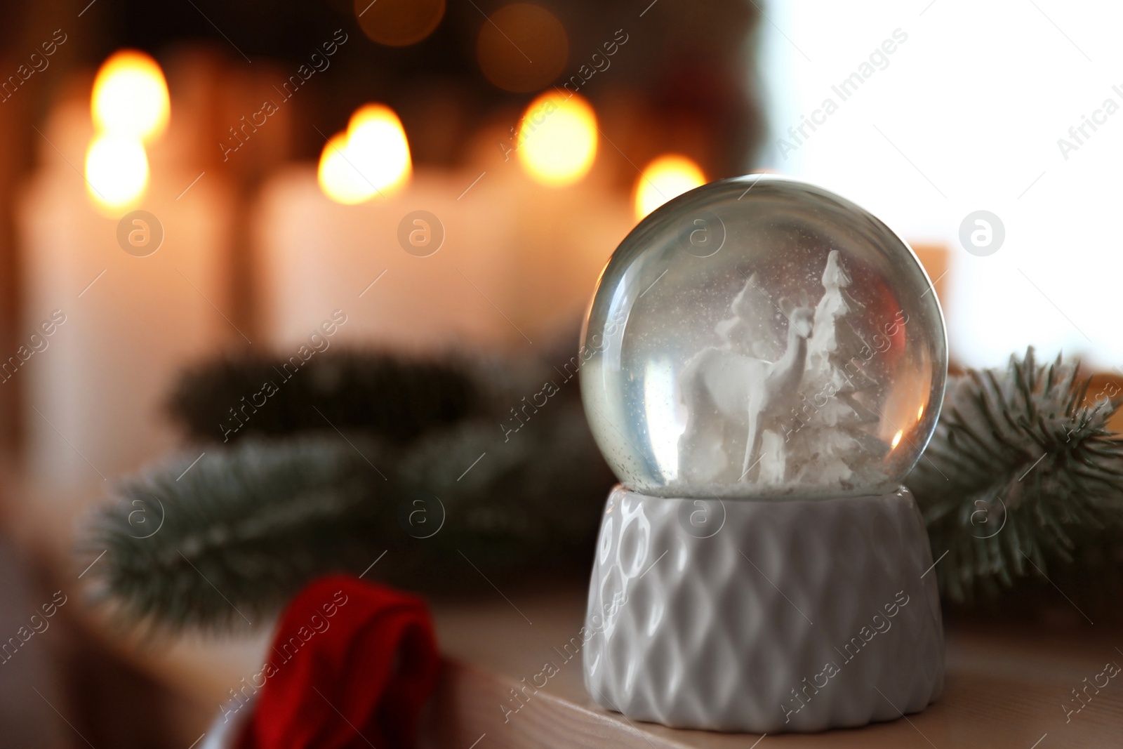 Photo of Snow globe on wooden table against blurred background. Space for text