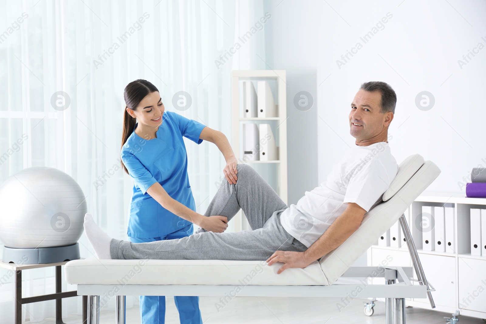Photo of Doctor working with patient in hospital. Rehabilitation physiotherapy