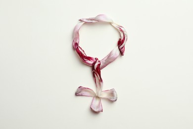 Photo of Female gender sign made of tulip petals on beige background, top view. Menopause concept
