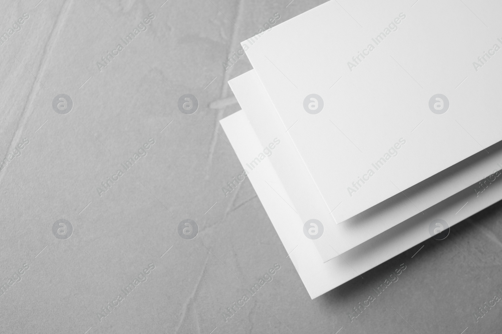 Photo of Blank business cards on light grey stone background, closeup. Mock up for design