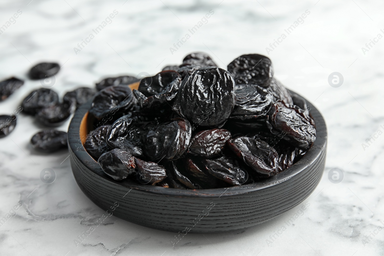 Photo of Plate of sweet dried plums on table. Healthy fruit