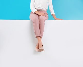 Photo of Woman wearing stylish shoes on color background, closeup