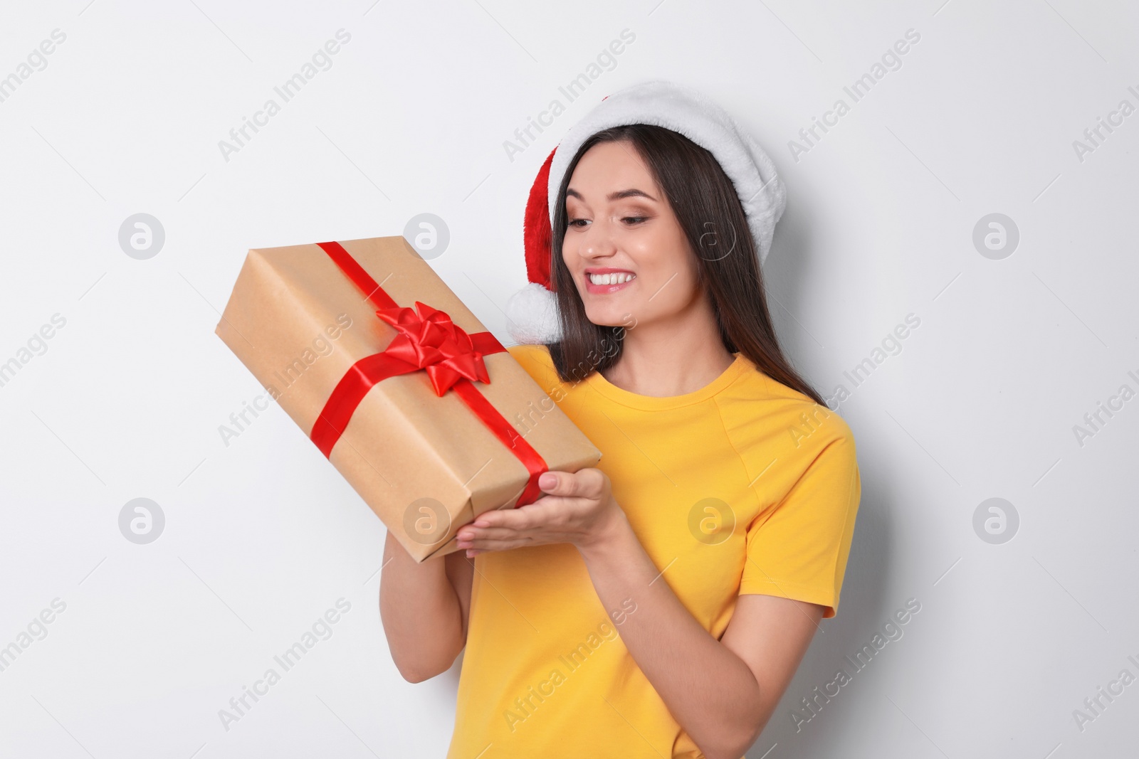 Photo of Young woman with Christmas gift on white background