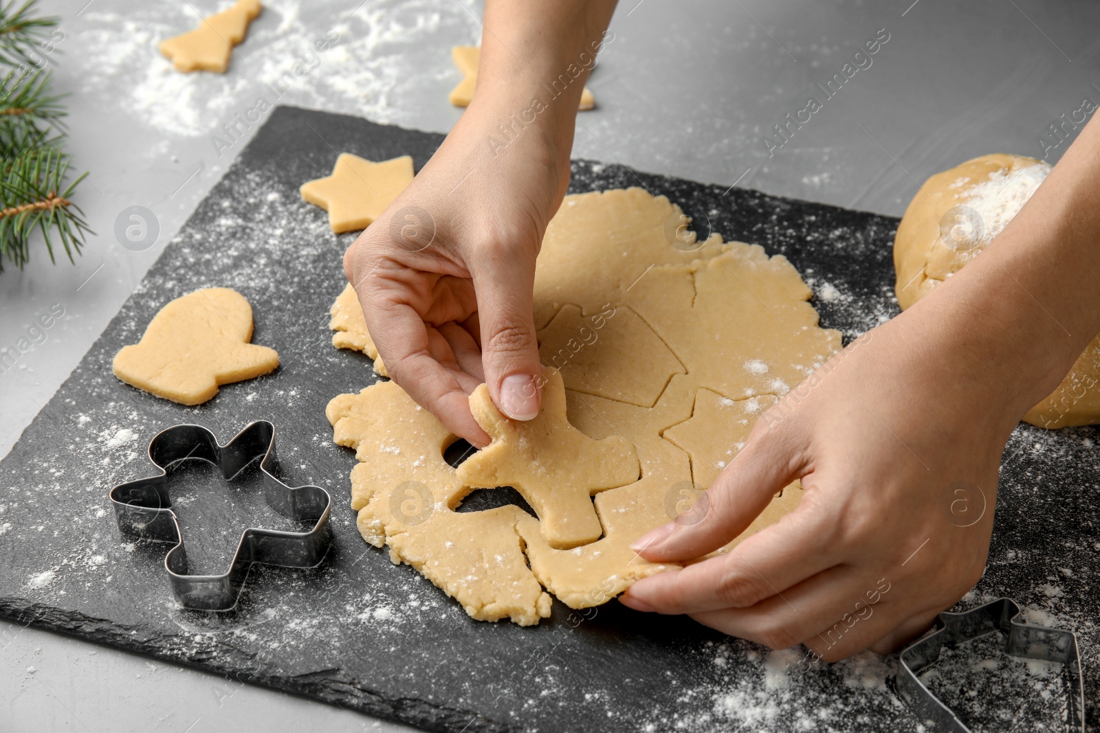 Photo of Young woman preparing Christmas cookies on table