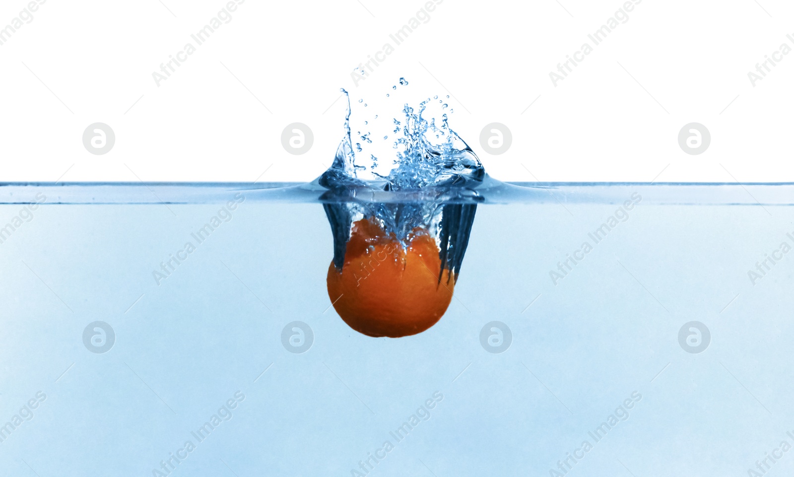 Photo of Tangerine falling down into clear water against white background