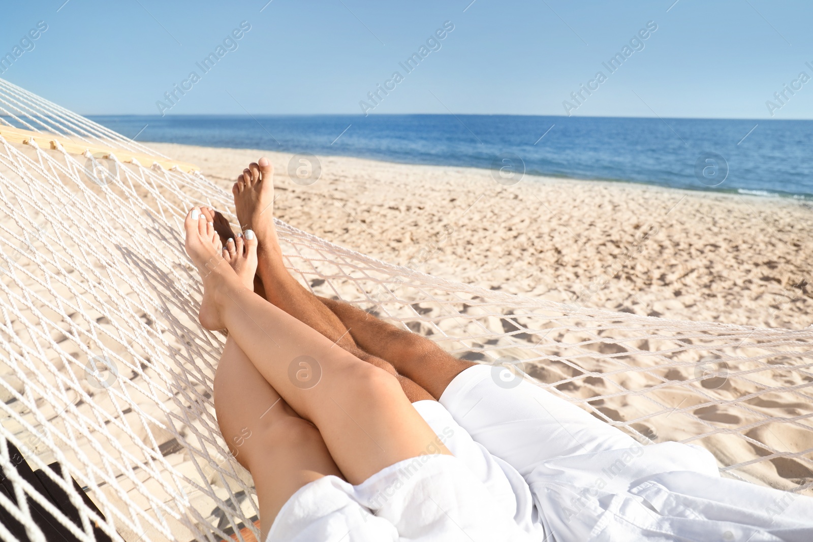 Photo of Couple relaxing in hammock on beach, closeup