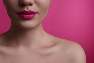 Photo of Closeup view of woman with beautiful full lips on pink background