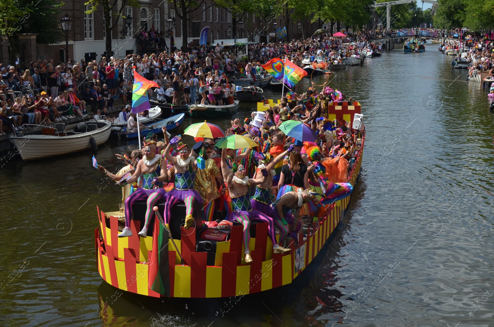 Photo of AMSTERDAM, NETHERLANDS - AUGUST 06, 2022: Many people in boats at LGBT pride parade on river