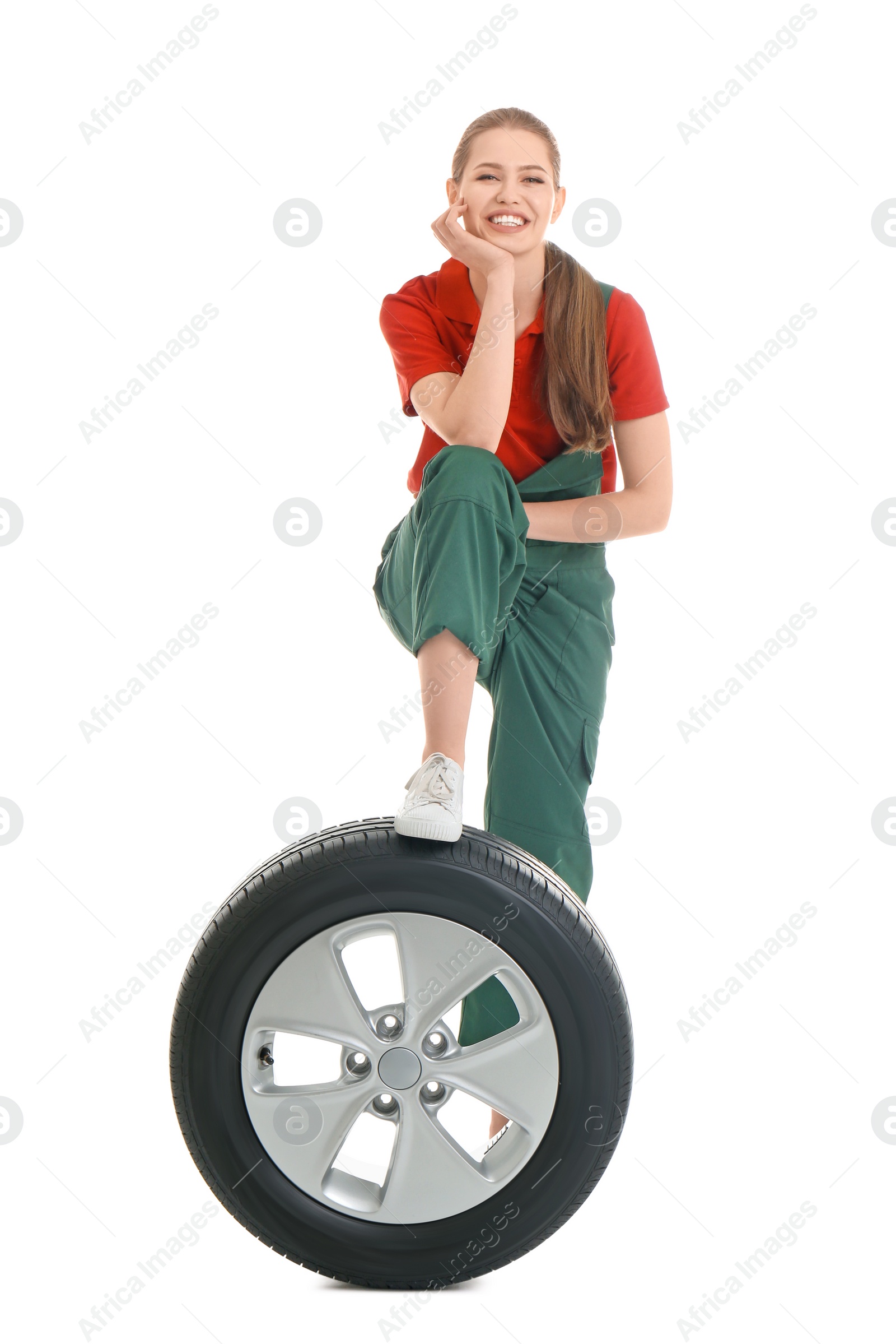 Photo of Female mechanic with car tire on white background