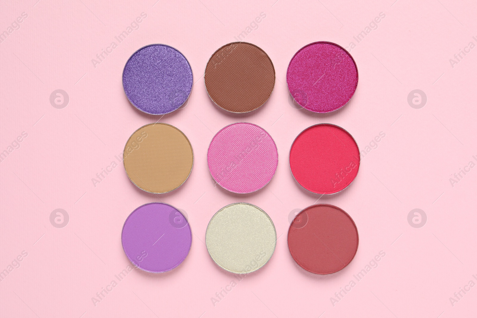 Photo of Different beautiful eye shadows on pink background, flat lay