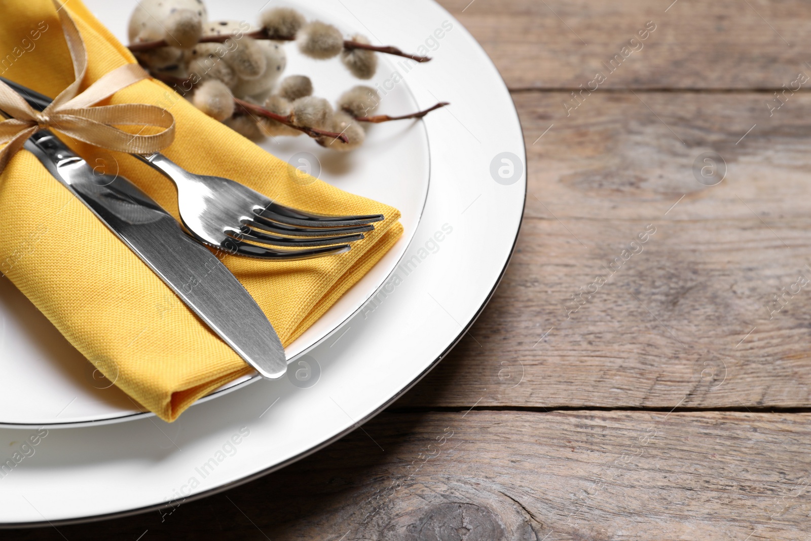 Photo of Festive Easter table setting on wooden background, closeup. Space for text