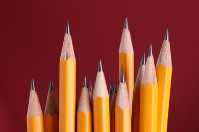 Many graphite pencils on burgundy background, macro view