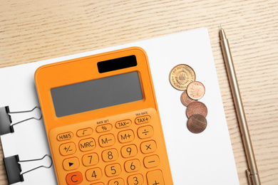Photo of Calculator, paper and money on wooden table, top view. Tax accounting