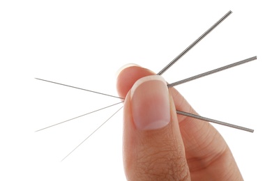 Photo of Woman holding needles for acupuncture on white background