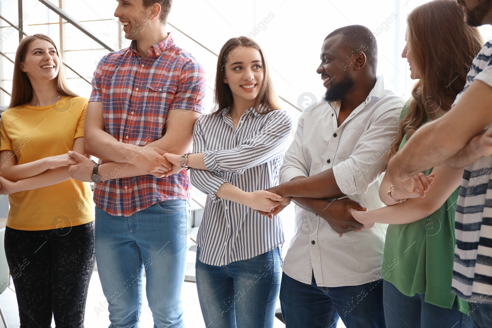 Photo of People holding hands on light background. Unity concept