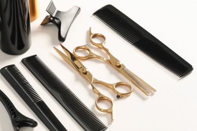 Hairdresser tools. Different scissors and combs on white table, closeup