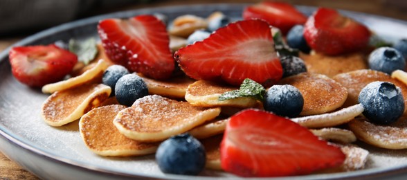 Photo of Cereal pancakes with berries on plate, closeup
