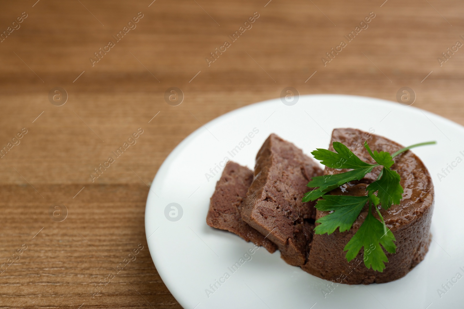 Photo of Plate with pate and parsley on wooden table. Pet food