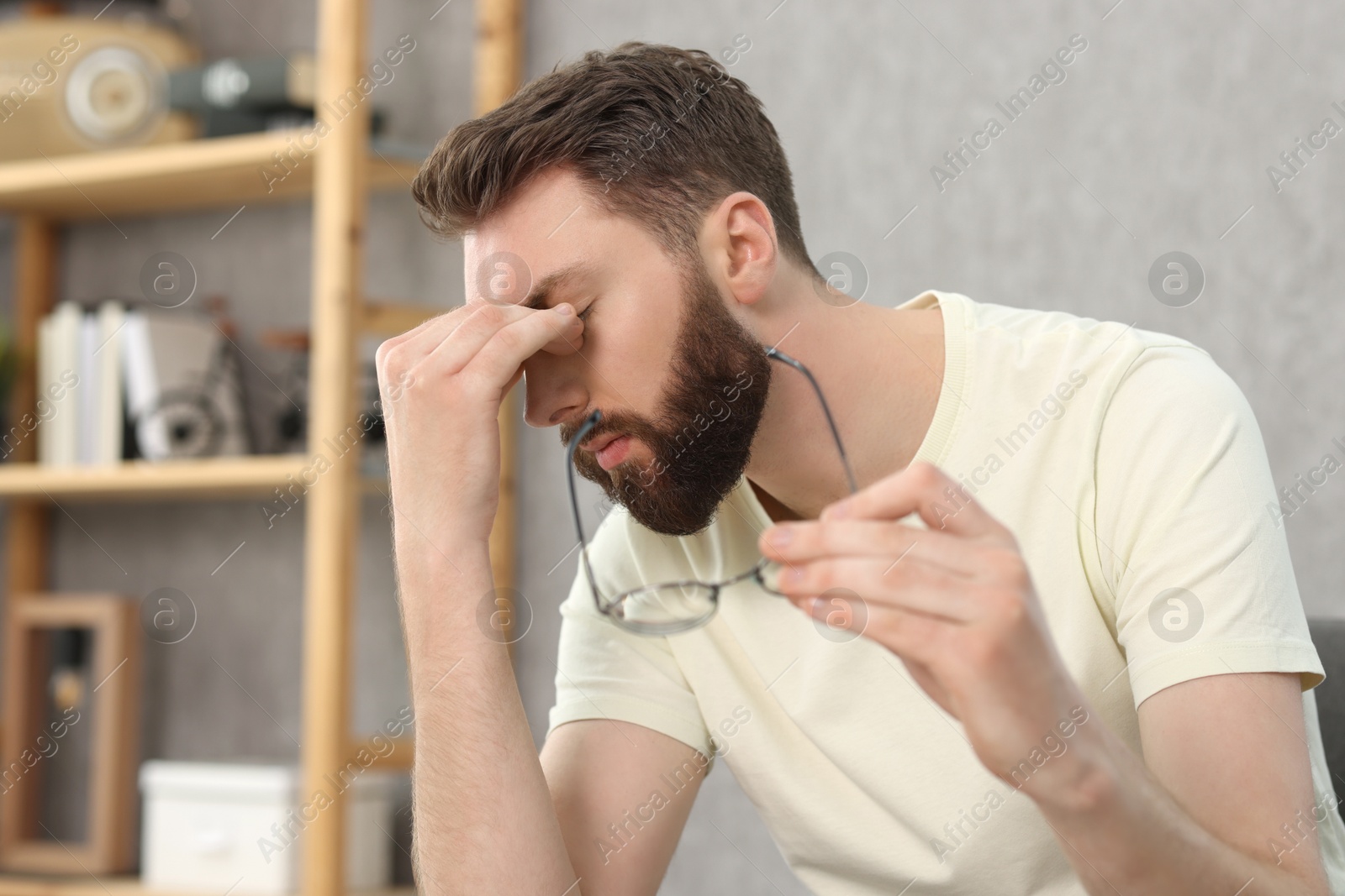 Photo of Overwhelmed man with glasses suffering at home