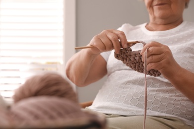 Elderly woman knitting at home, closeup. Creative hobby