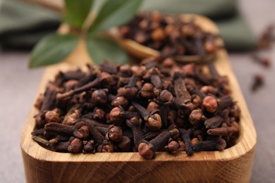 Photo of Aromatic cloves in bowl on table, closeup