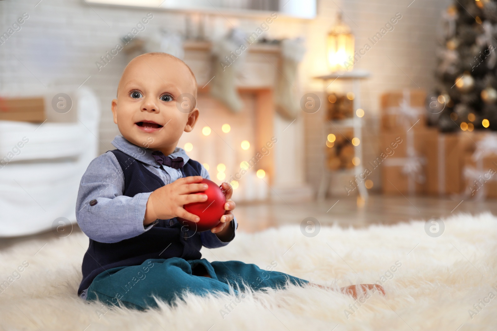 Photo of Little baby playing with Christmas ball on floor at home