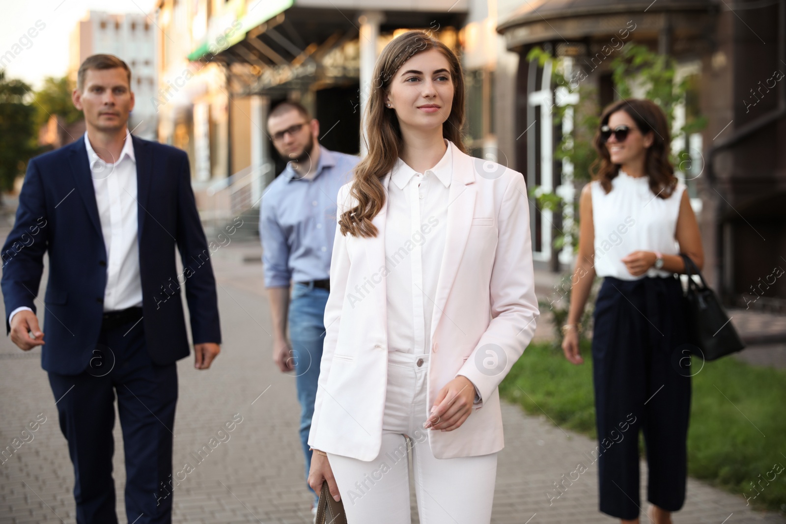 Photo of Different people walking on modern city street