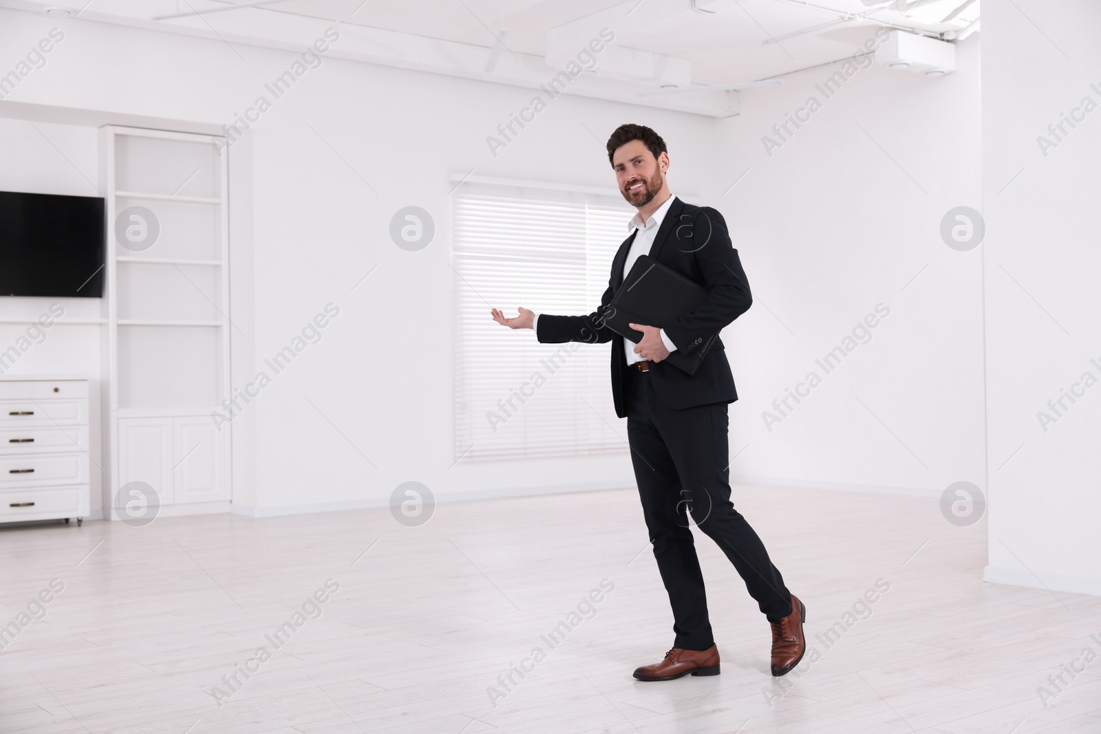 Photo of Happy real estate agent showing new apartment