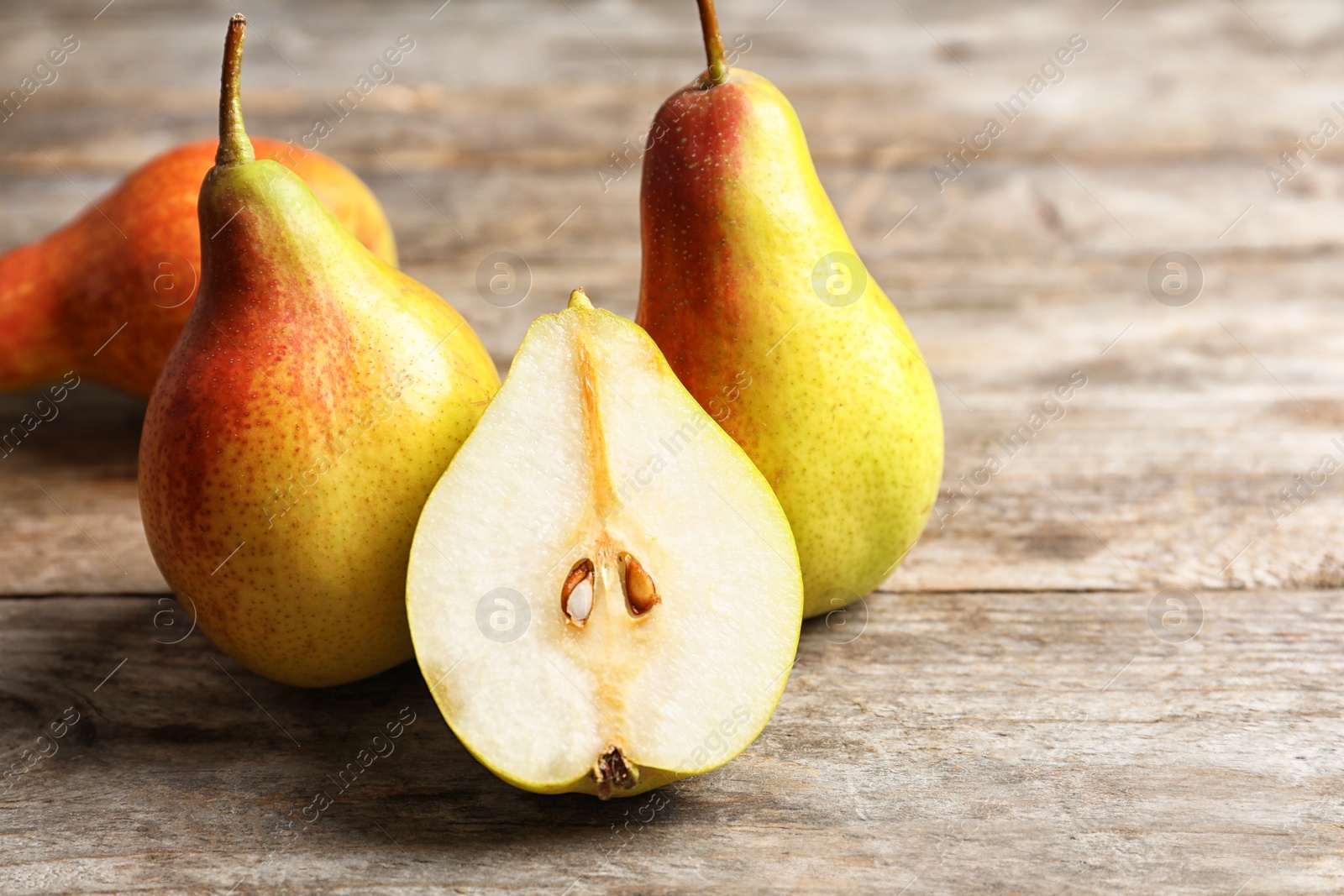 Photo of Ripe pears on wooden table. Space for text