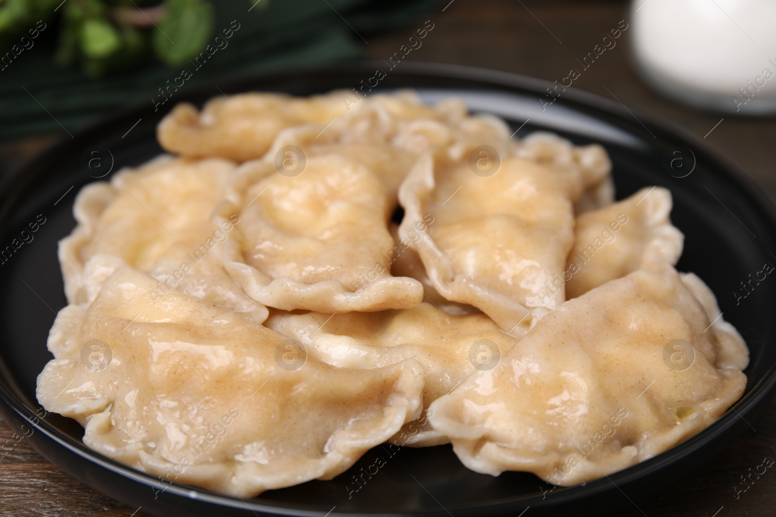 Photo of Plate of delicious dumplings (varenyky) with cottage cheese on table, closeup