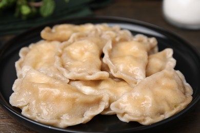 Photo of Plate of delicious dumplings (varenyky) with cottage cheese on table, closeup