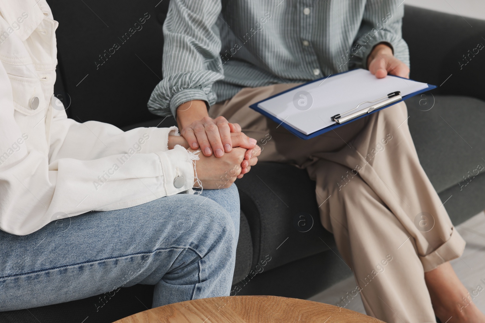 Photo of Psychologist working with teenage girl on sofa, closeup. Teenager problems