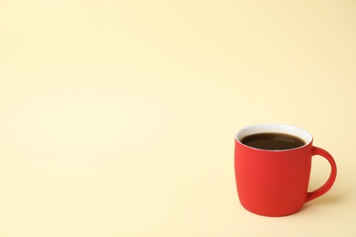 Red ceramic cup with hot aromatic coffee on color background