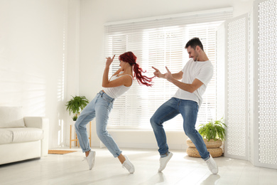 Photo of Beautiful young couple dancing in living room