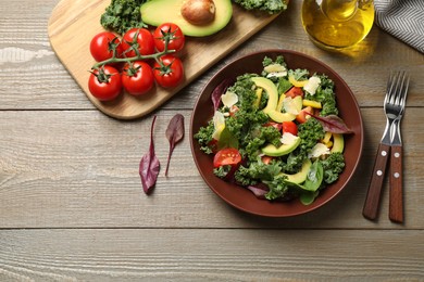 Tasty fresh kale salad on wooden table, flat lay