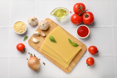 Ingredients for lasagna on white tiled table, flat lay