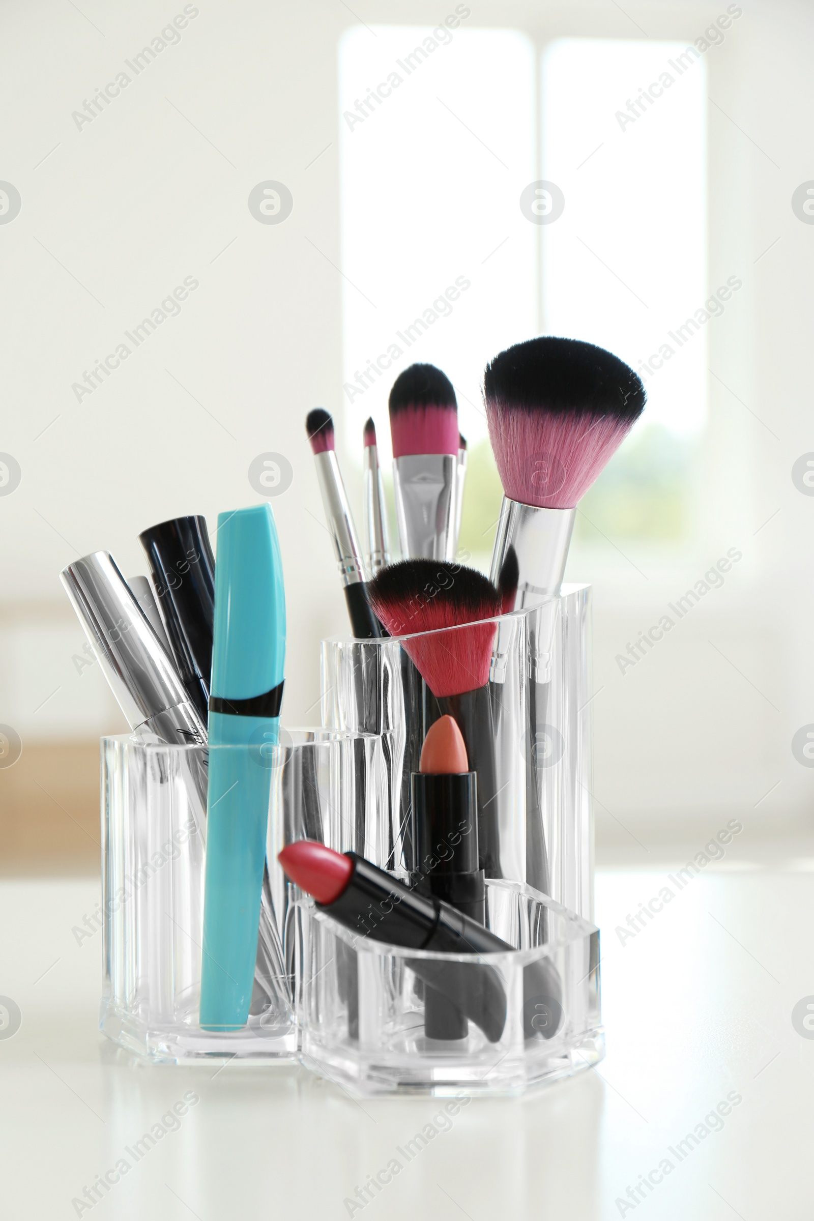 Photo of Organizer with cosmetic products for makeup on table indoors