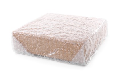 Photo of Cardboard box packed in bubble wrap isolated on white