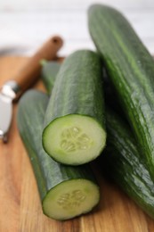 Photo of Many fresh cucumbers on wooden board, closeup