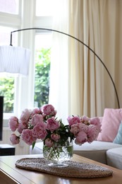 Beautiful pink peonies in vase on table at home, space for text. Interior design